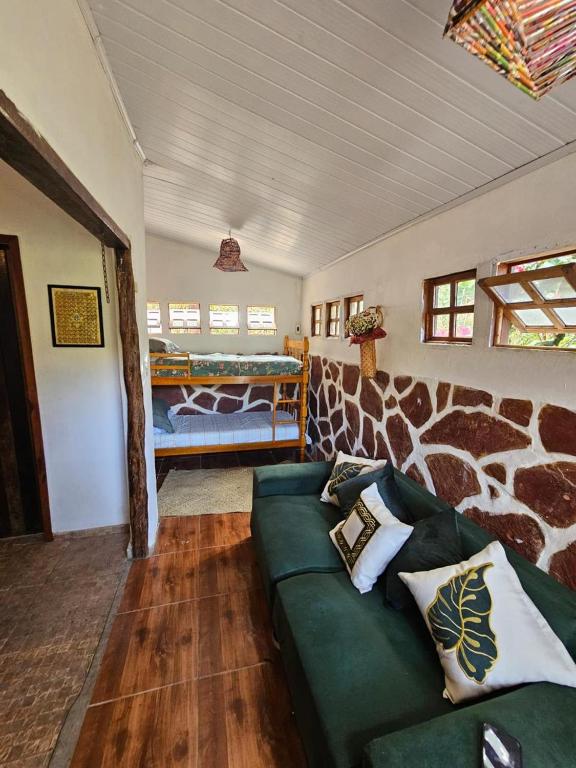 a living room with a green couch and a bed at Viva o Capao - Casas in Palmeiras