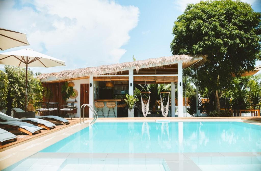 a swimming pool with a patio and a house at The Wander Nest Villas in Panglao Island