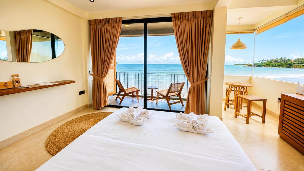a bedroom with a bed with a view of the ocean at Meli Beach in Galle