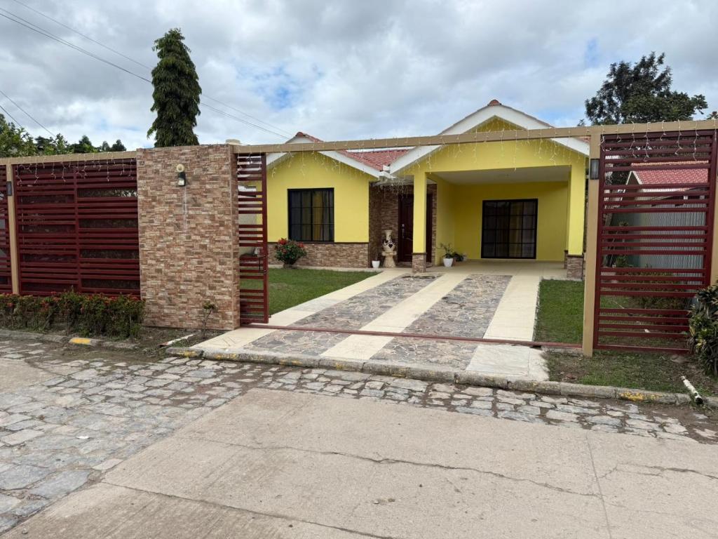 a house with a brick and yellow at Aloft Alvarado in Siguatepeque