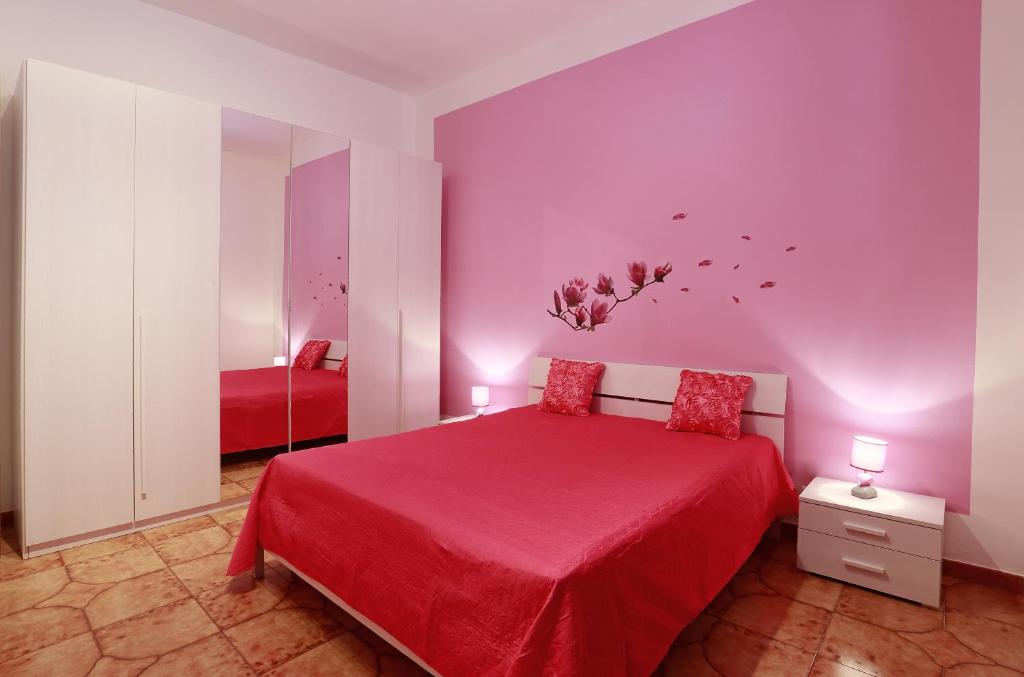 una camera con letto rosso e pareti viola di Casa Pagani a Nardò