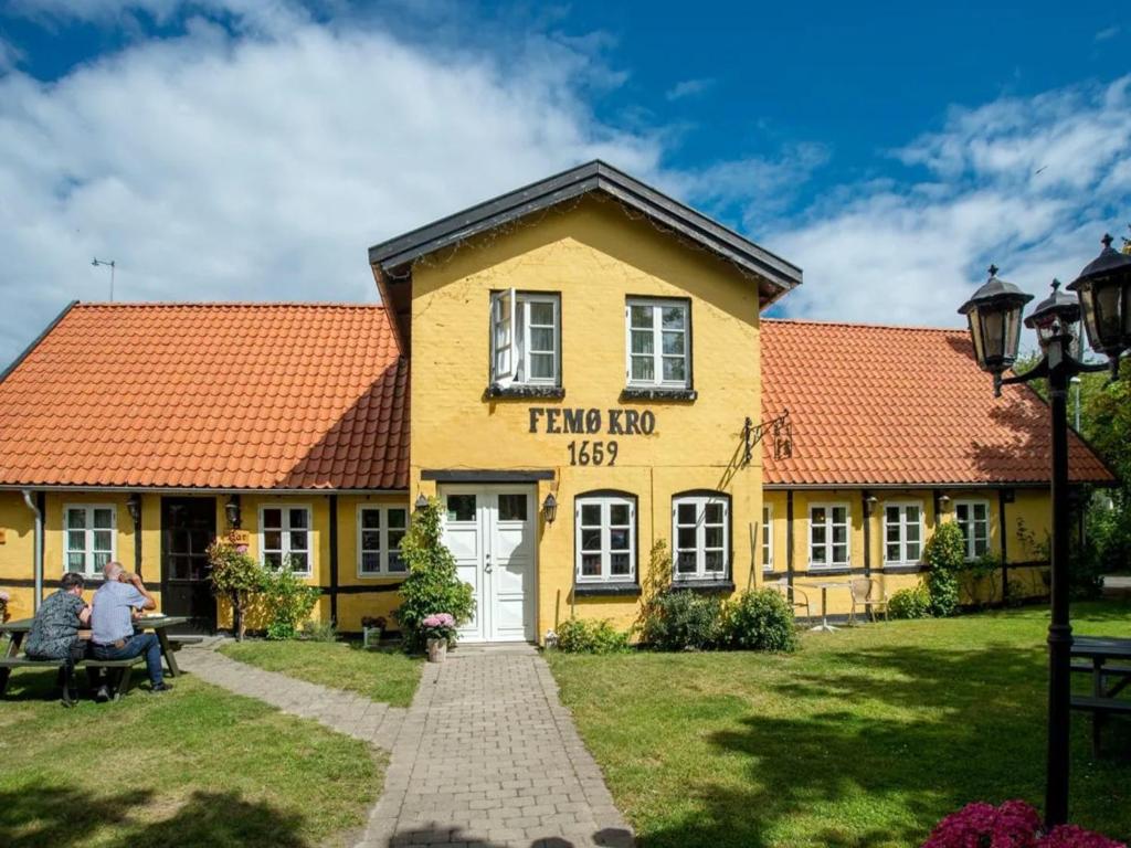 a yellow building with an orange roof at Femo Kro & Feriecenter by DanCenter in Nørreby