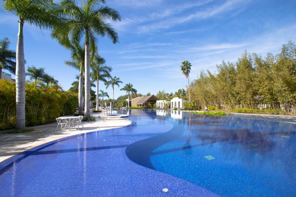 a large swimming pool with palm trees in the background at Departamento Taheima Nuevo Vallarta in Nuevo Vallarta