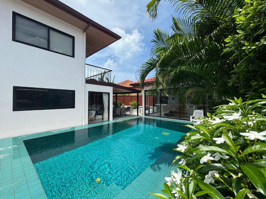 a swimming pool in front of a house at Big leaf villa kohsamui in Bangrak Beach