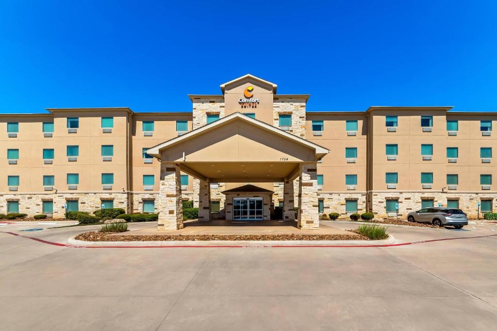 a large building with a parking lot in front of it at Comfort Suites San Antonio North - Stone Oak in San Antonio