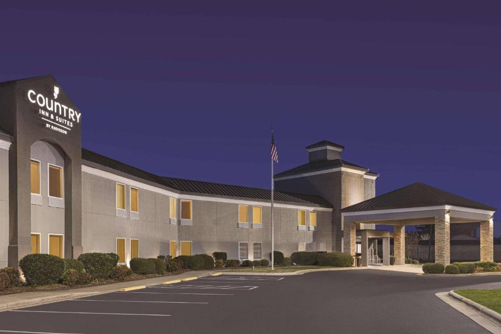 a building with a flag in front of it at Country Inn & Suites by Radisson, Dunn I-95 in Dunn