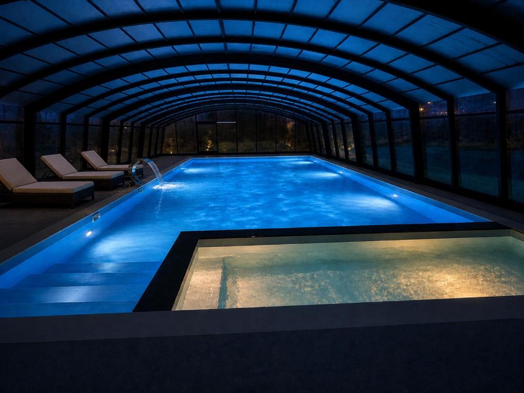 a swimming pool in a building with a tunnel at Nowe komfortowe domki Albatros in Łeba