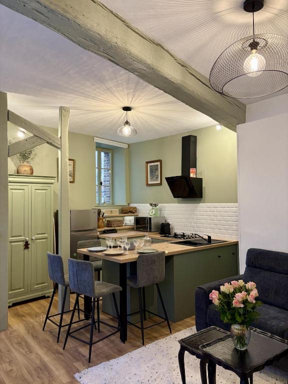 a kitchen and living room with a table and chairs at L'Escapade Maillotine in Joigny