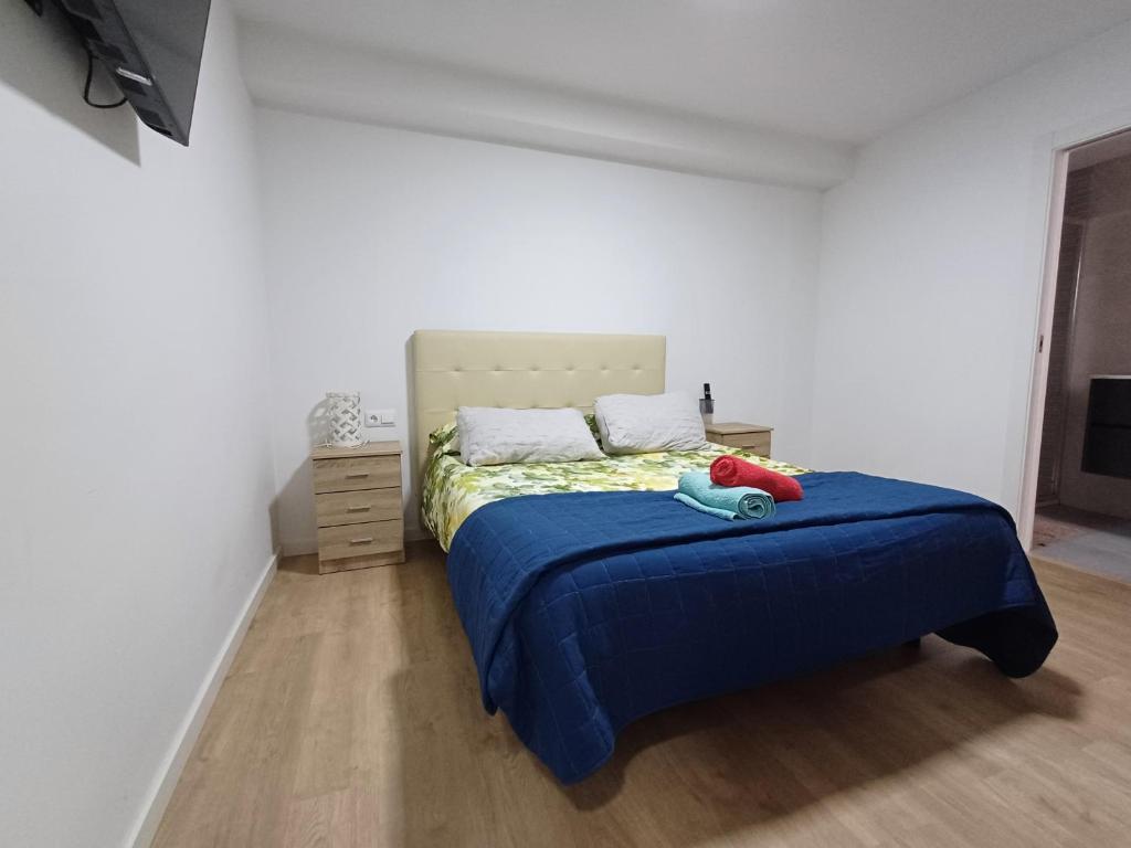 a bedroom with a bed with a blue blanket at Carbo Home y Garaje , Algemesí Home in Algemesí