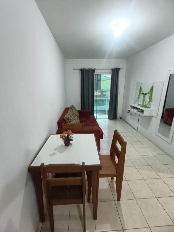 a living room with a table and a couch at Apartamento simples com vista para a praça in Palhoça