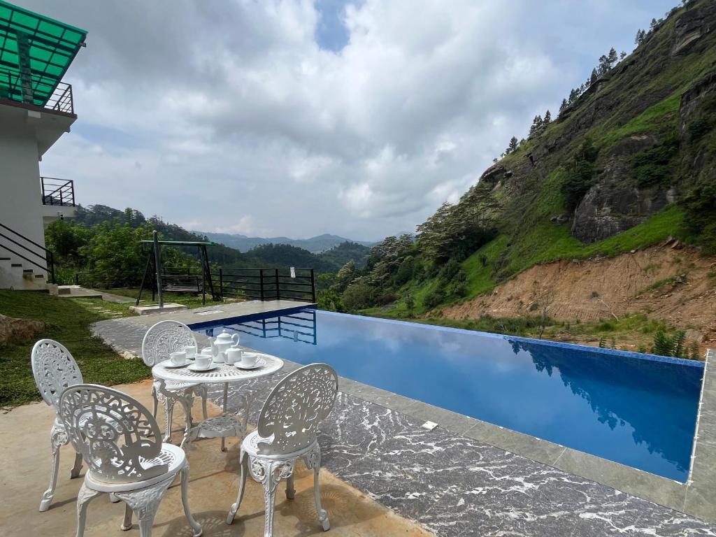 a patio with a table and chairs next to a swimming pool at Stone Gale Estate Villa in Galaha Town