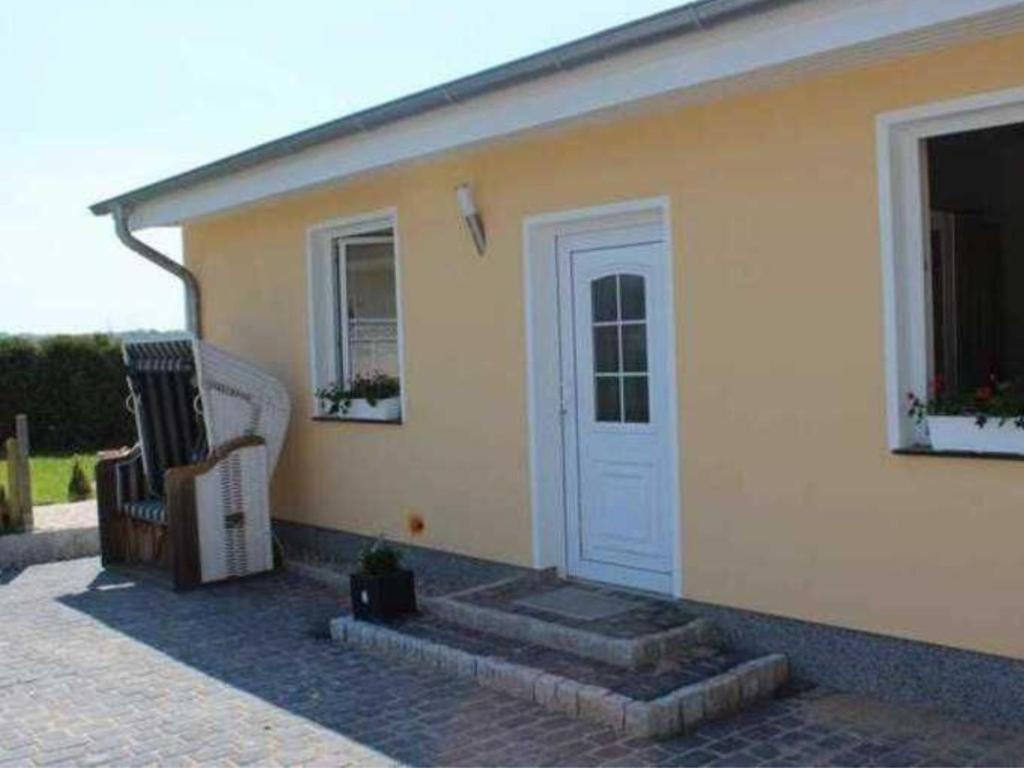 a house with a white door and a chair at Ferienhaus Ostsee Antje Bellmann in Kemnitz