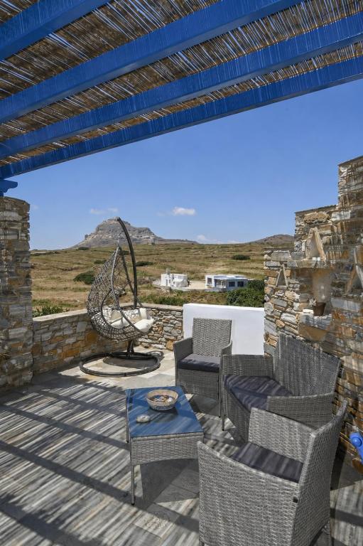 a patio with chairs and a table with a view at Tzados Sunny Villa in Kariá