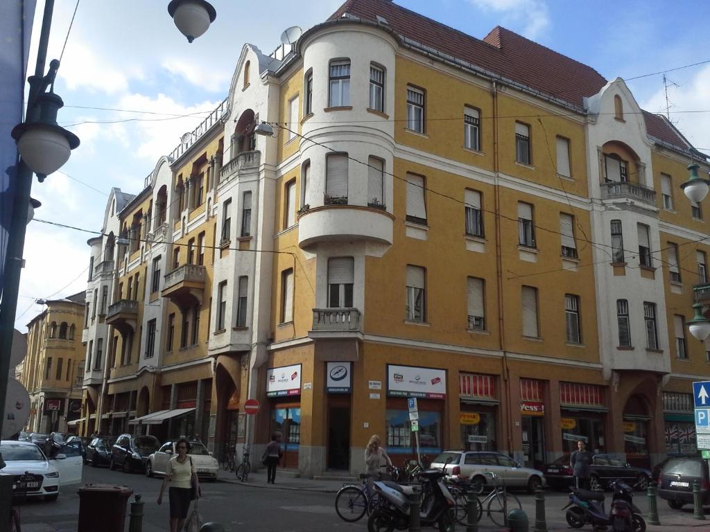 a group of buildings on a city street with cars at Klauzál Apartment in Szeged