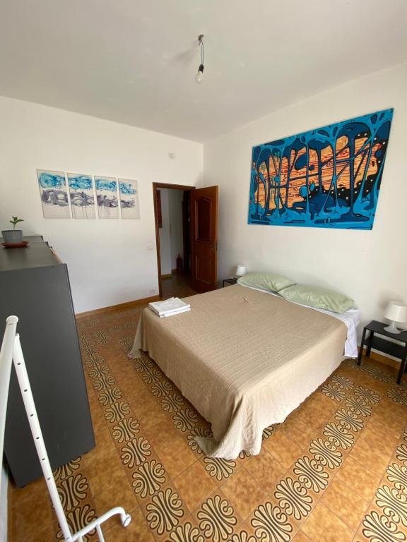 a bedroom with a bed and a painting on the wall at Stanza matrimoniale bagno privato in Mola di Bari