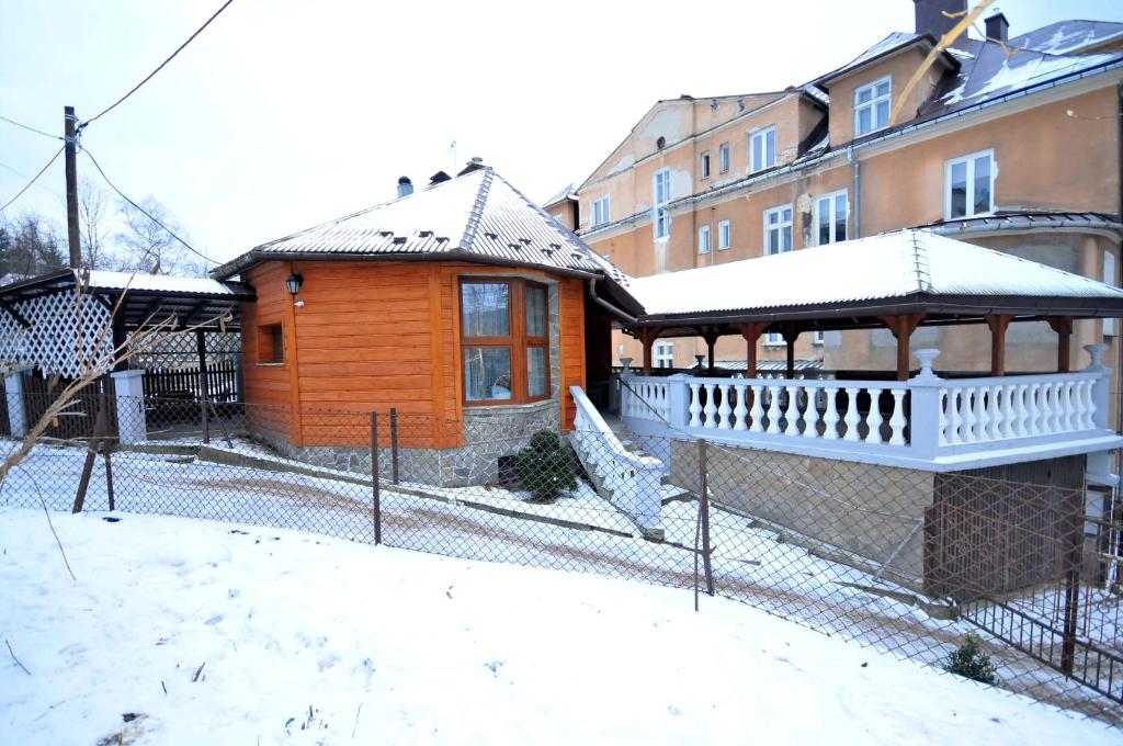 a wooden house with a gazebo in the snow at Apartament U Jacka in Rabka-Zdrój