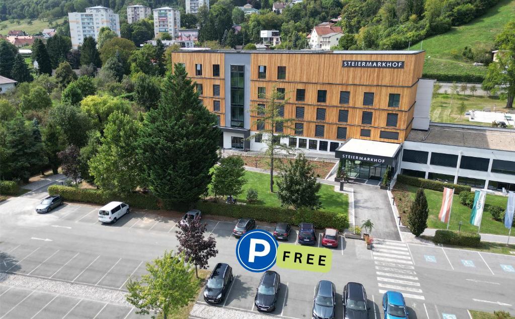 ein Parkplatz mit Autos, die vor einem Gebäude geparkt sind in der Unterkunft Hotel Steiermarkhof Graz - von Herzen steirisch in Graz
