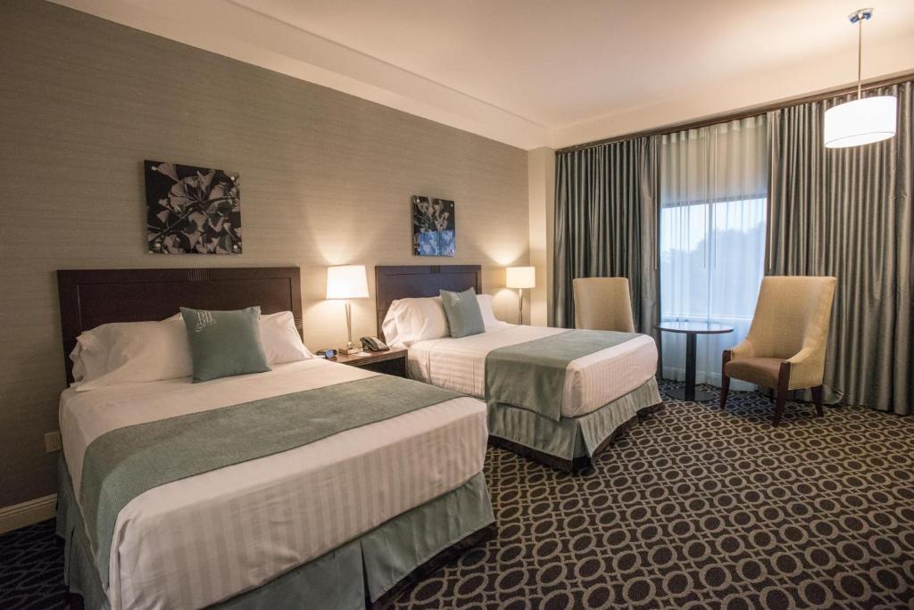 Cette chambre comprend 2 lits et une fenêtre. dans l'établissement Brent House Hotel, à La Nouvelle-Orléans