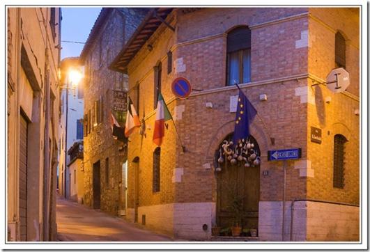 a building with flags on the side of a street at Il Pozzo Della Citerna in Castelnuovo Berardenga