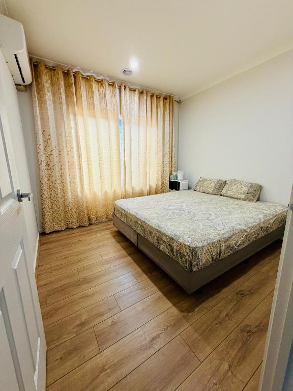 a bedroom with a bed and a wooden floor at The Quiet Stay in Wyndham Vale