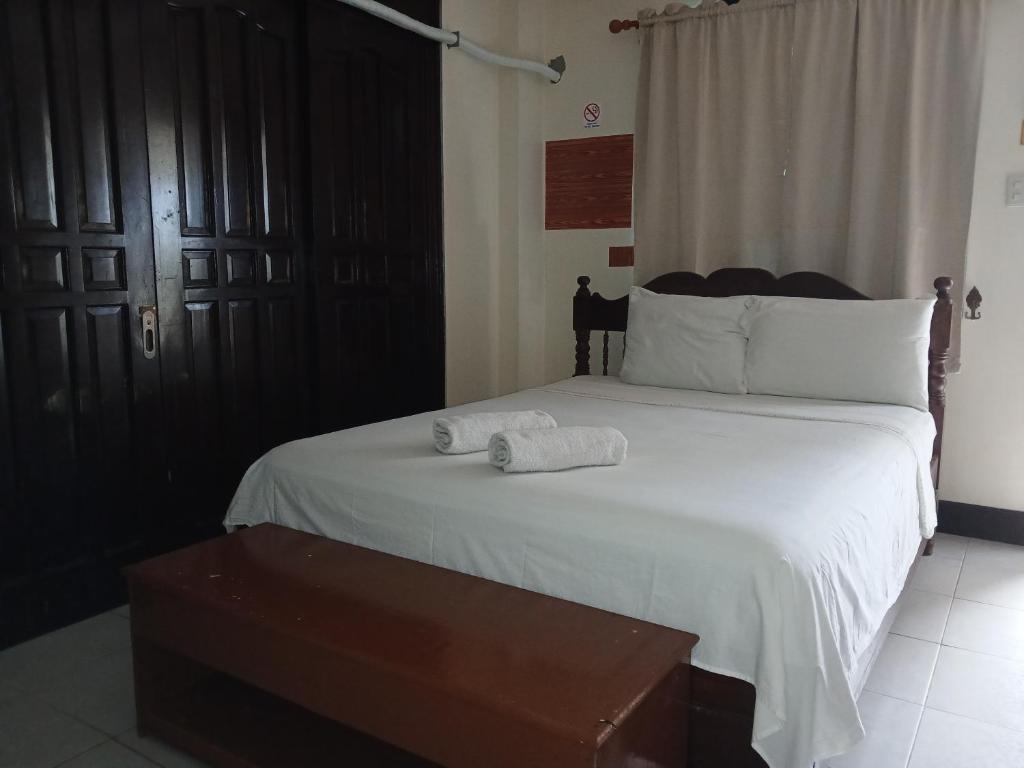 a bedroom with a large bed with white sheets at JM-RN Pensione House in Padre Burgos