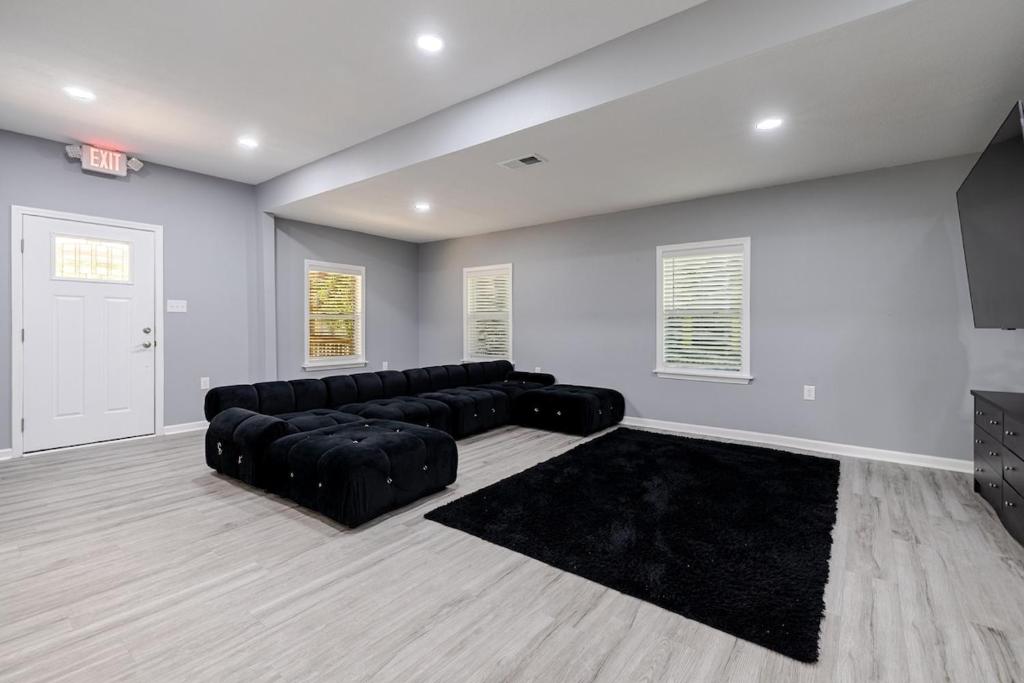 a living room with a black leather couch in a room at Large 3 bed 2 bath home in Mobile