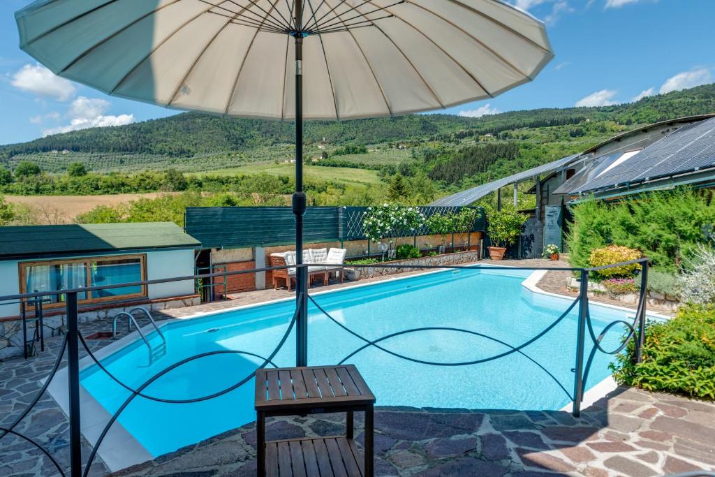 an umbrella sitting next to a swimming pool at Guest House Fantaccini con Piscina in Pelago