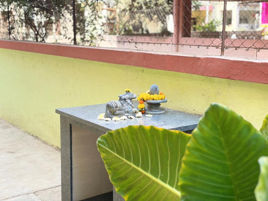 a table with a figurine and a bowl of fruit at My second home at Nashik in Nashik