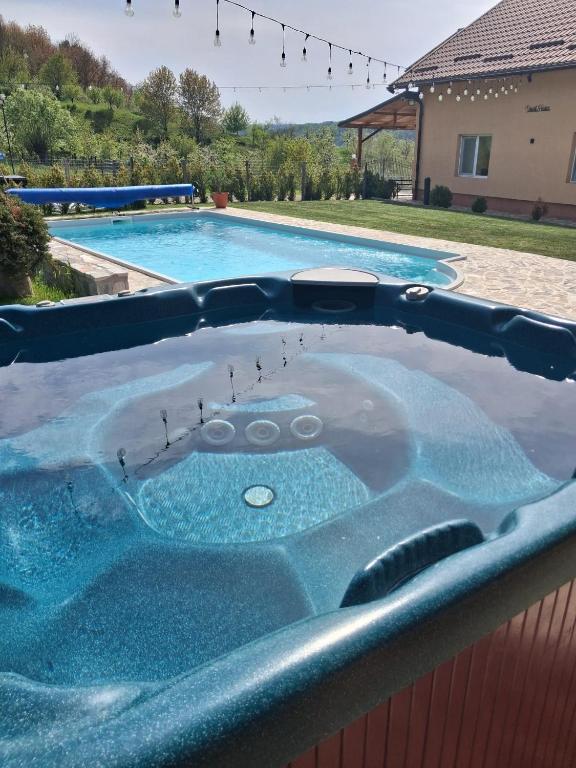 a jacuzzi tub in front of a swimming pool at David House Piscina incalzita si jacuzzi in Pietrari
