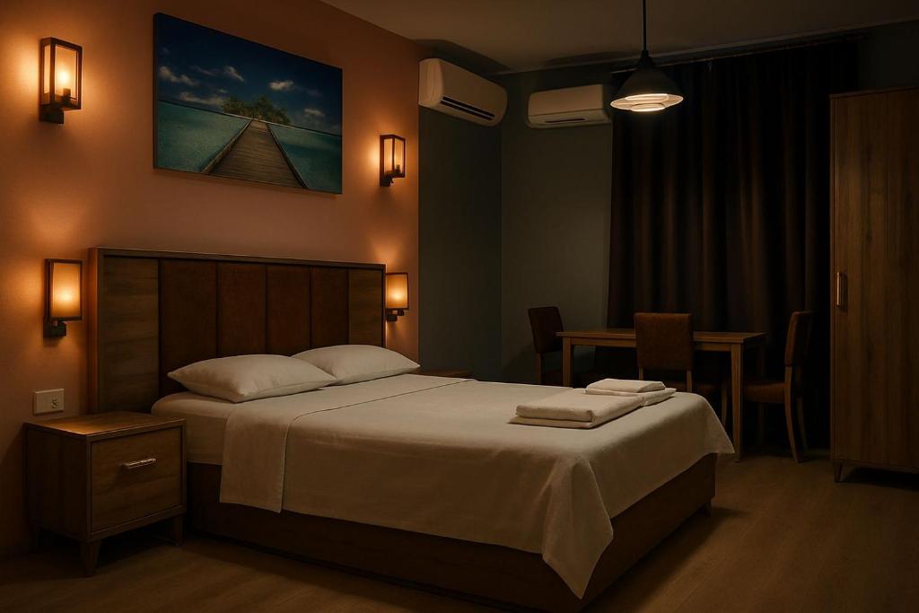 a bedroom with a large bed and a table at Elizim Otel in İzmir