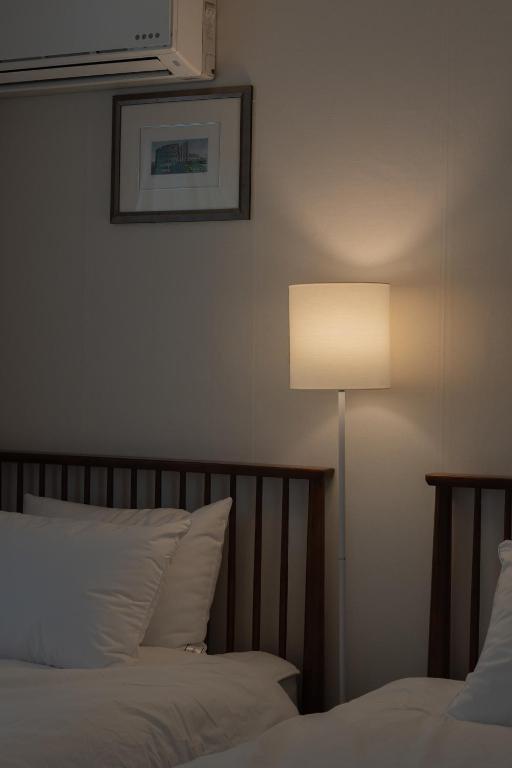 a bedroom with a bed and a lamp next to it at 선스테이 in Ilsan-ni