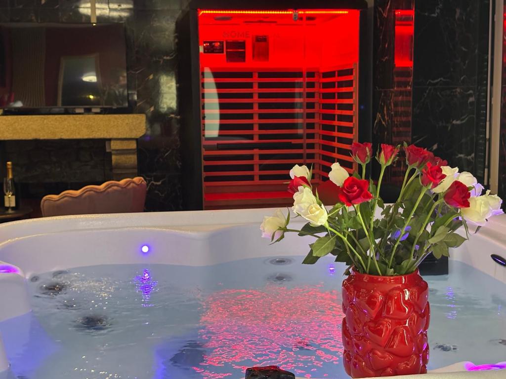 a vase filled with flowers sitting in a bath tub at Le Cocon secret - Sauna - Jacuzzi in Quimperlé