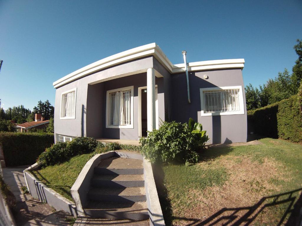 una pequeña casa blanca con un camino que conduce a ella en Casa en Balneario Sol y Rio en Villa Carlos Paz