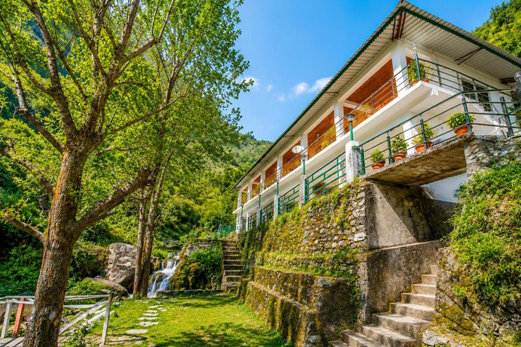 a house on the side of a hill with a waterfall at Babutaal Resort in Chakrāta
