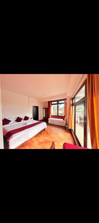 a bedroom with two beds and a large window at Hocia Homestay in Shillong