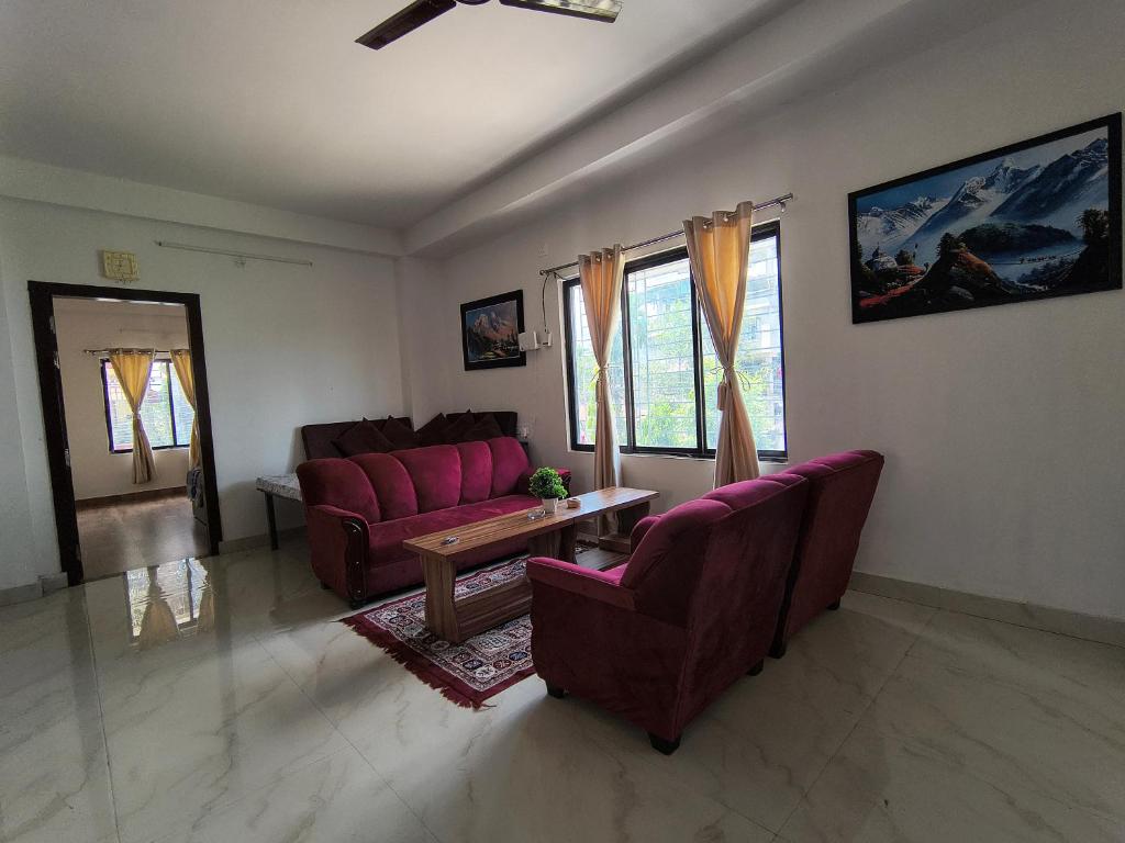 a living room with purple couches and a table at PnH Stays in Siliguri