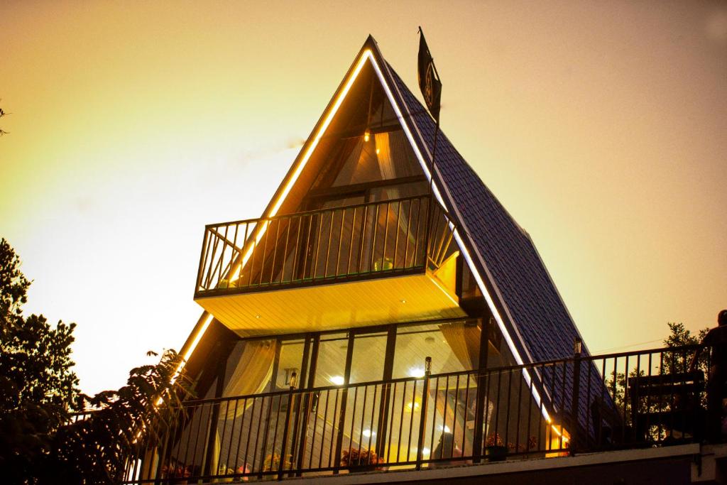 a yellow house with a gambrel roof with a balcony at Infinite cabana in Ella