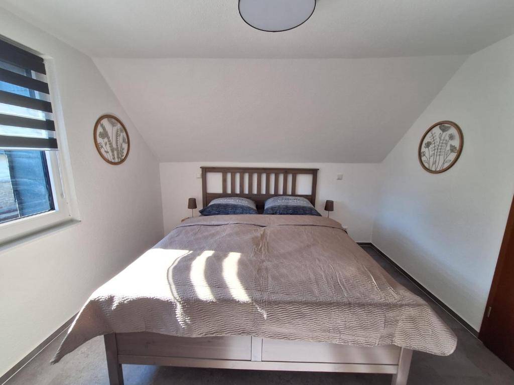 a bedroom with a bed with two clocks on the wall at Nest and Nature Strauch in Simmerath
