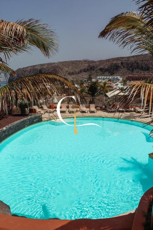 a large blue swimming pool with a water slide at Casa Lucia in Palm-Mar