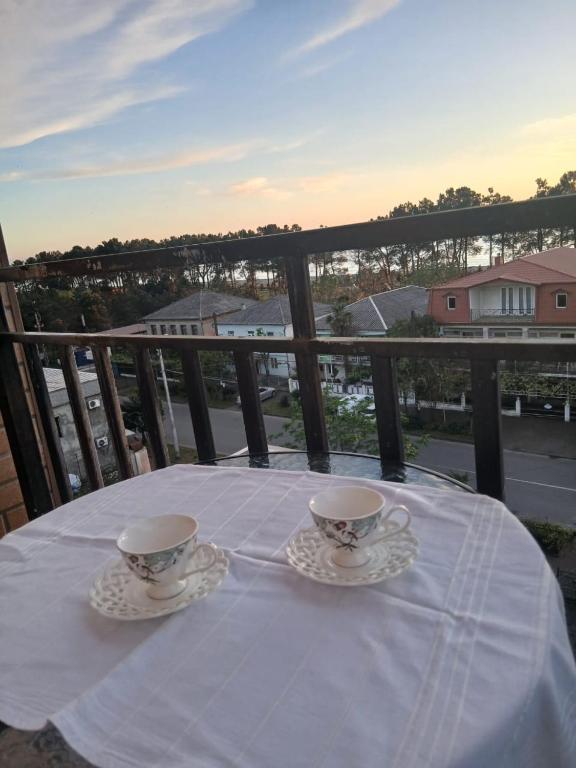 two cups and saucers on a table on a balcony at Квартира возле стадиона in Kobuleti
