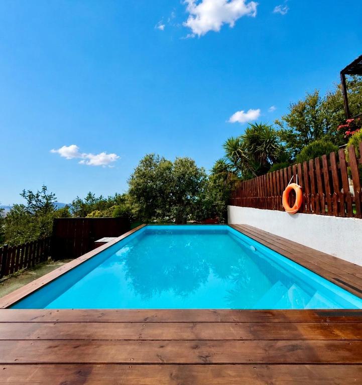 a swimming pool in a backyard with a wooden fence at Apokas Country House in Zoopiyi