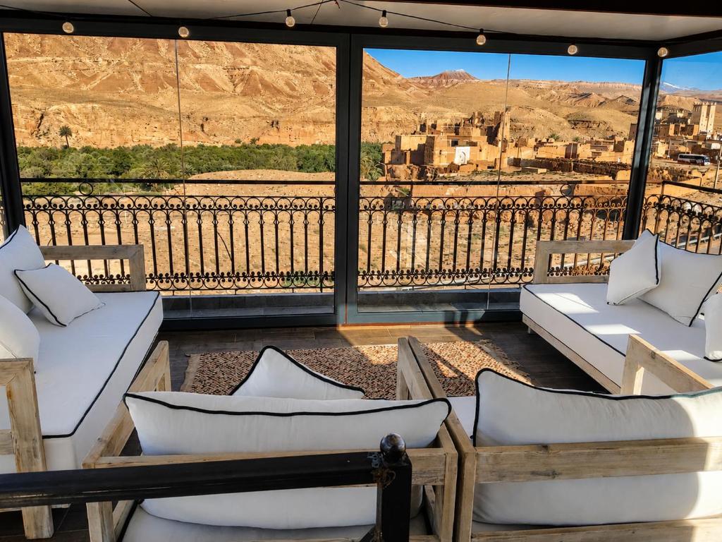 a balcony with couches and a view of a city at Villa A'Kabar Guest House in Aït Benhaddou