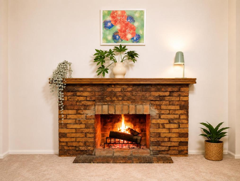 a living room with a brick fireplace with a plant at Yarrawonga Holiday House with Open Fireplace in Yarrawonga