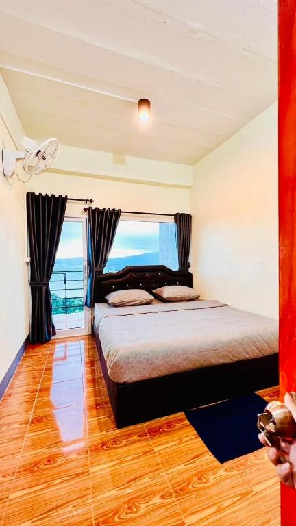 a bedroom with a bed with a view of the ocean at สบายดีโฮมสเตย์ภูลังกา in Ban Sakoen