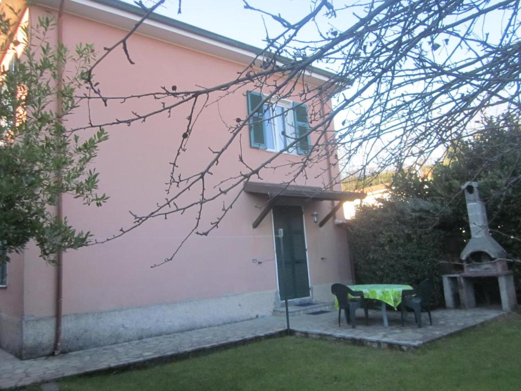 a pink house with a table and chairs in the yard at Cà di Boschetti Old Farm f in La Spezia