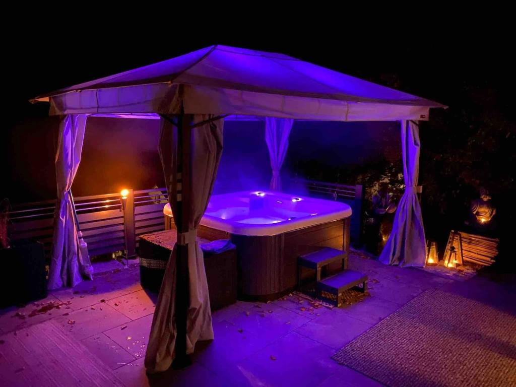 a hot tub under a canopy at night at Spa-Villa mit privatem Whirlpool&Sauna und Panoramablick in Wellheim