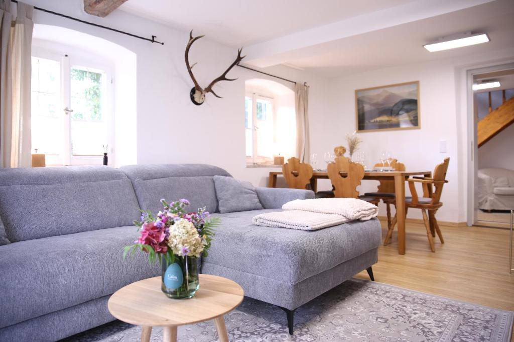 a living room with a blue couch and a table at Ferienwohnung Oswald mit Garten im EG in Kochel