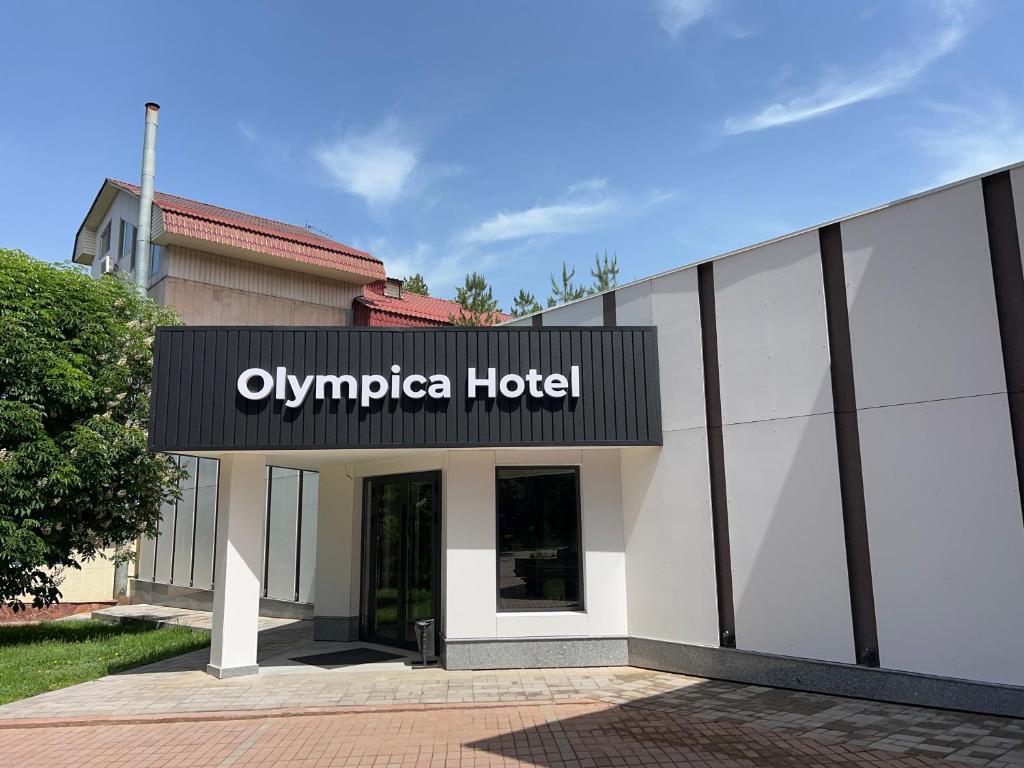 a building with an olympia hotel sign on it at Olympica Hotel in Almaty