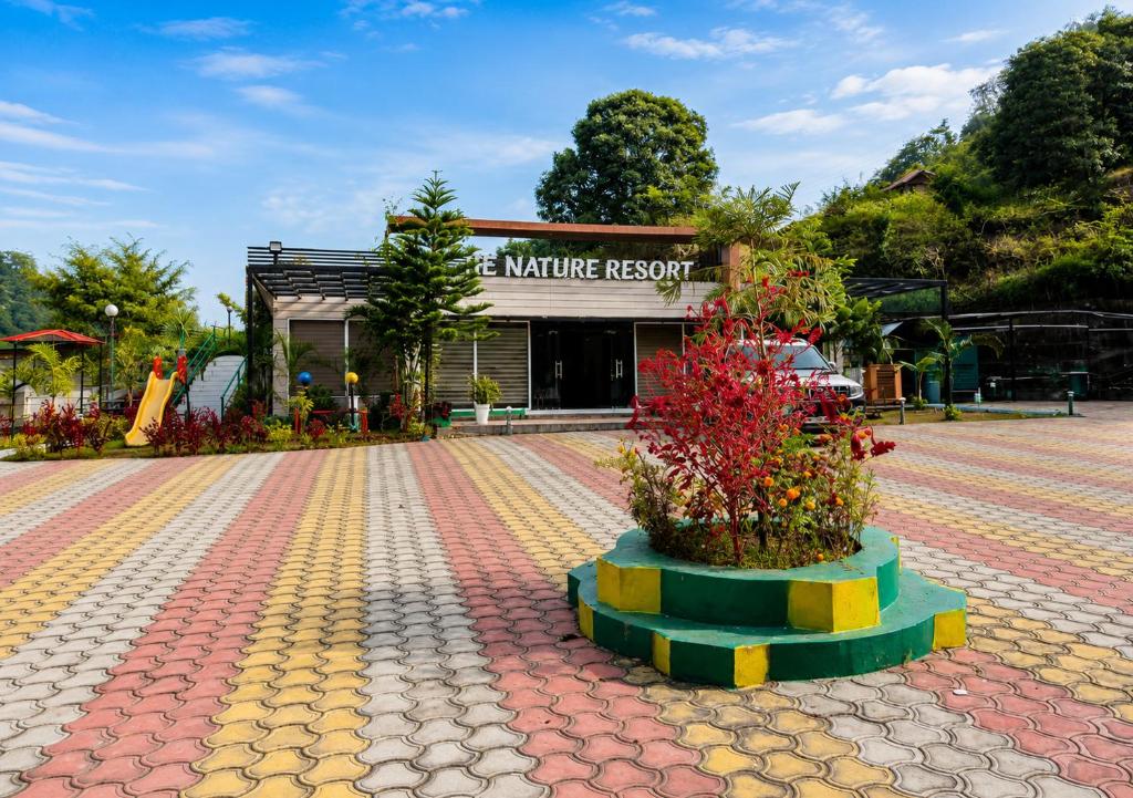 a building with two plants in front of it at HR The nature resort in Birbhaddar