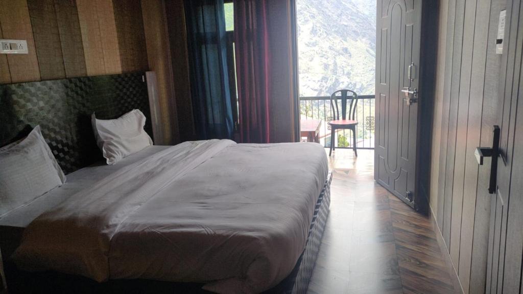 a bedroom with a bed and a door to a balcony at Rupli homestay in Joshīmath